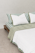 Hand block printed reversible cotton quilt with scallop border and check pattern in sage green and pastel blue. Made in Sanganer, Jaipur using 100% cotton with hand quilting.